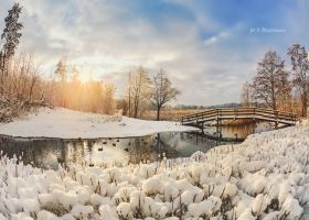 Obraz przedstawia mostek nad rzeką Mień w okresie zimowym